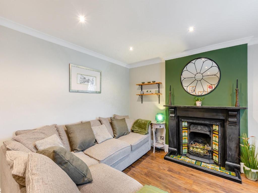 a living room with a couch and a fireplace at Mill Cottage in Clitheroe