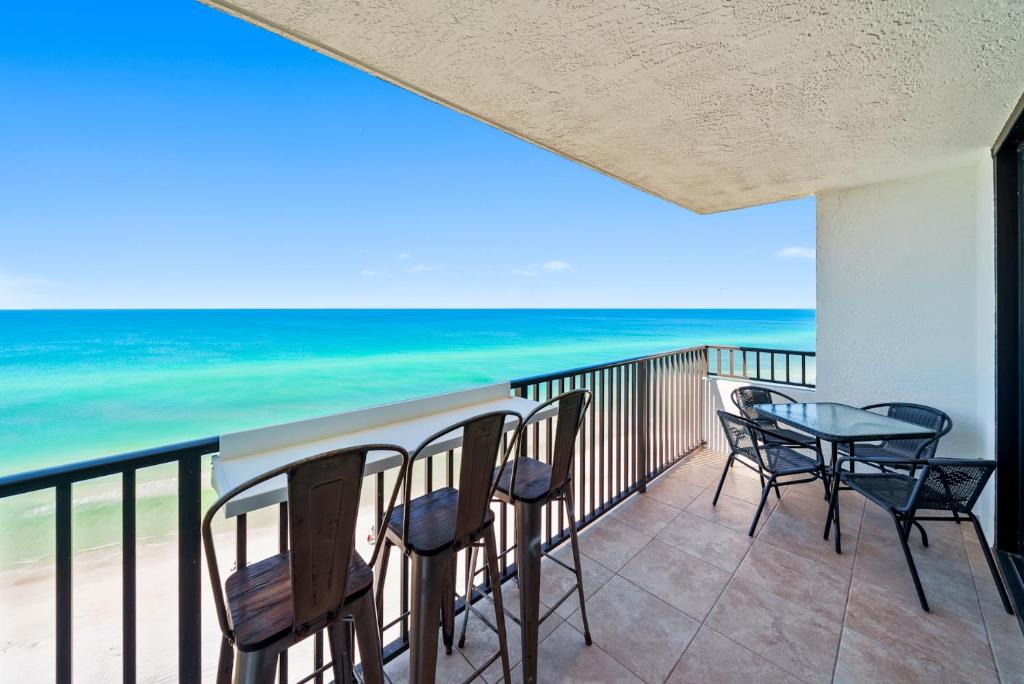a balcony with chairs and a table and the ocean at One Seagrove Place #1308 - "Love at First Sight" in Santa Rosa Beach