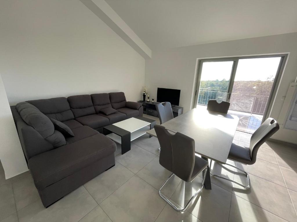 salon z kanapą i stołem w obiekcie Apartments Lia-Jolie w mieście Umag