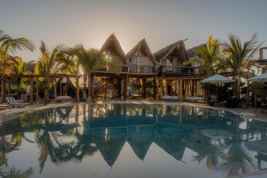 a large swimming pool in front of a house at Baja Nomads Hotel - Adults 15 Plus in Todos Santos