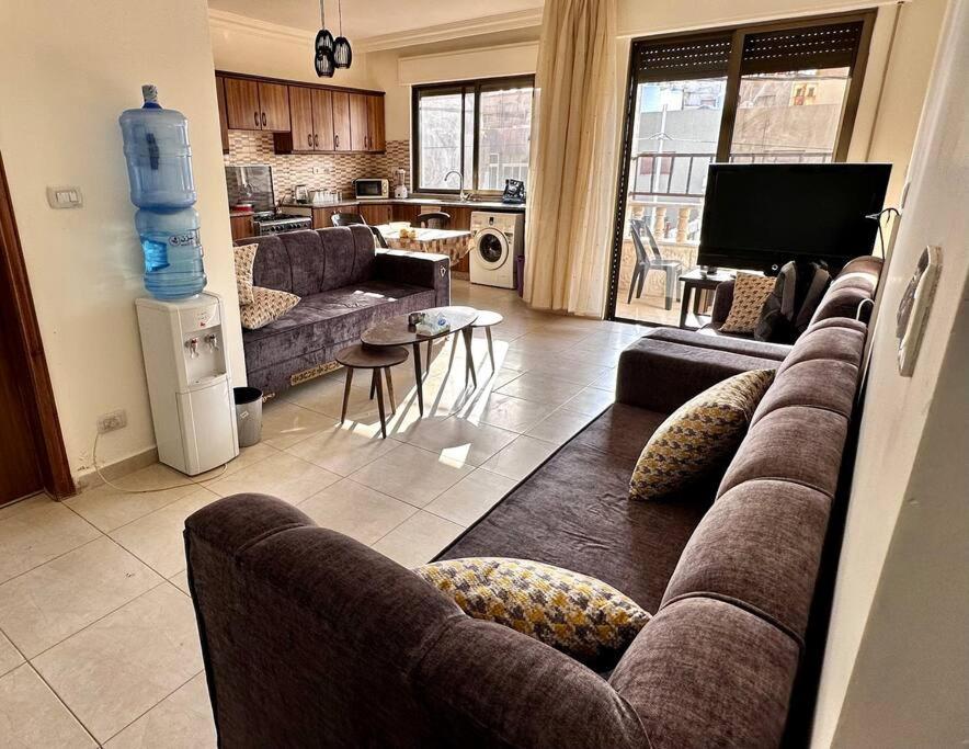 sala de estar con 2 sofás y cocina en 4 Bedroom Flat in Madaba with AC, en Madaba