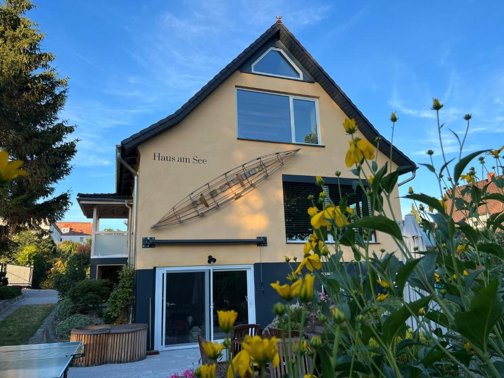 a house with a lot of yellow flowers in front of it at Ferienhaus "Haus am See" in Prenzlau