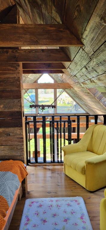 Ptasia Osada في Gardna Wielka: غرفة معيشة مع أريكة صفراء ونافذة