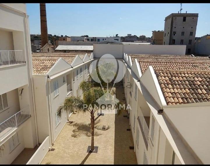 - une vue sur un bâtiment avec un palmier au milieu dans l'établissement appartamento nel residence felicita, à Balestrate