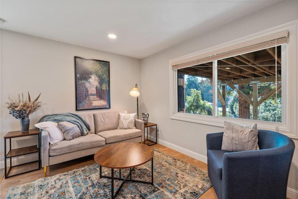 a living room with a couch and a table and a window at Central Crocker Highlands Garden Oasis in Oakland