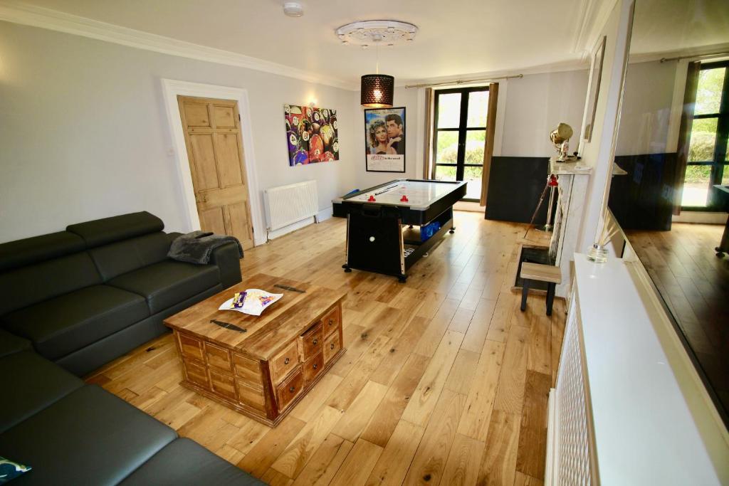 a living room with a couch and a pool table at Llanfair Hall, Dog Friendly, Cinema, Games Room, Hot Tub in Llanfairpwllgwyngyll