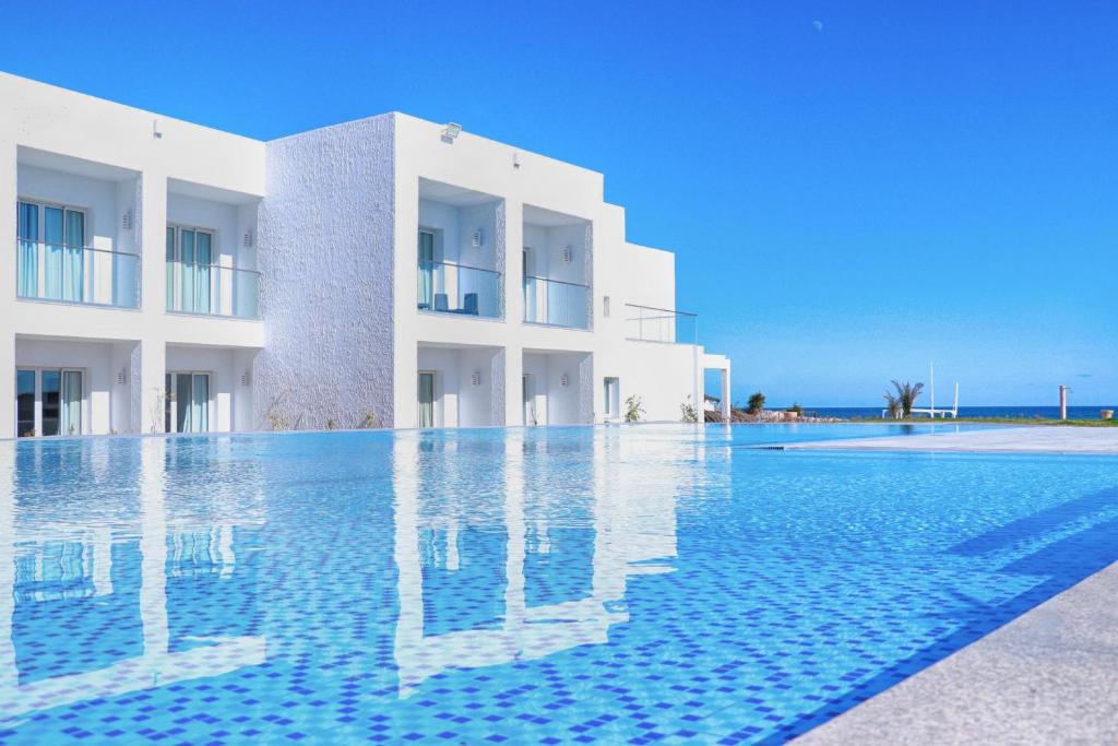 a swimming pool in front of a white building at Amber El Fell in Hammamet Nord