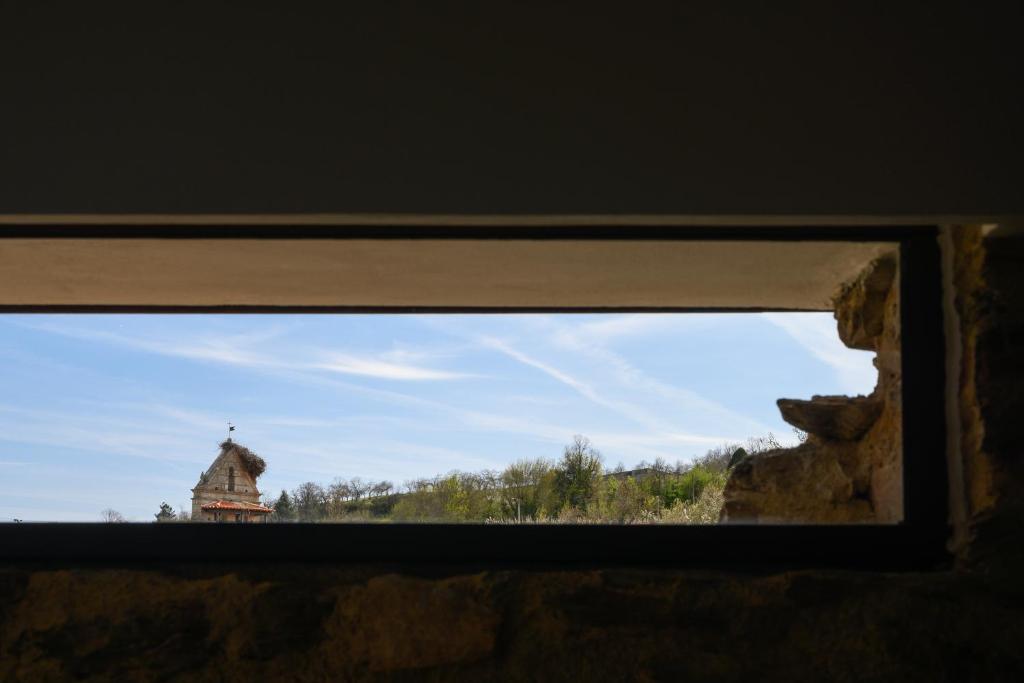 een raam met uitzicht op een klokkentoren in de verte bij Casa do Ferreiro in Macedo de Cavaleiros
