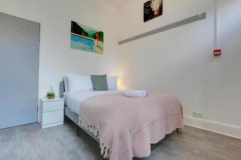 a bedroom with a bed with a pink blanket at Convenient 1-Bed Apartment - Ideal for Working Away, Free Parking, Pet Friendly, Netflix in Sheffield