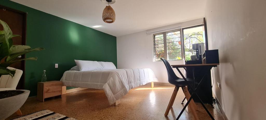 a bedroom with green walls and a bed with a desk at Habitación privada en el Poblado. Lo mejor de Medellín muy cerca in Medellín