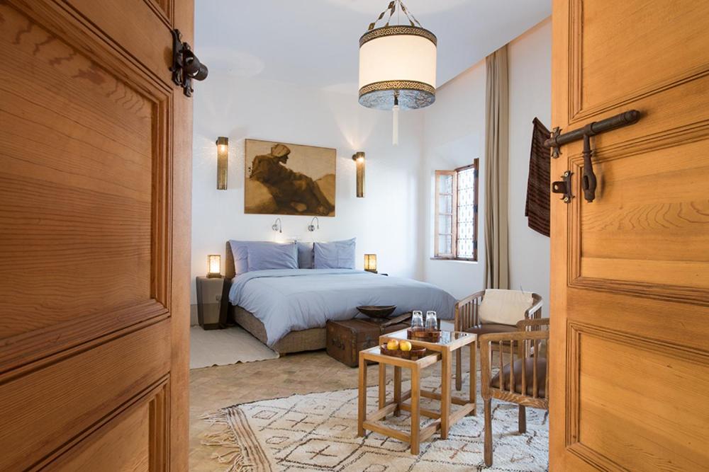 1 dormitorio con 1 cama y 1 mesa enfrente en Riad Rossi en Marrakech