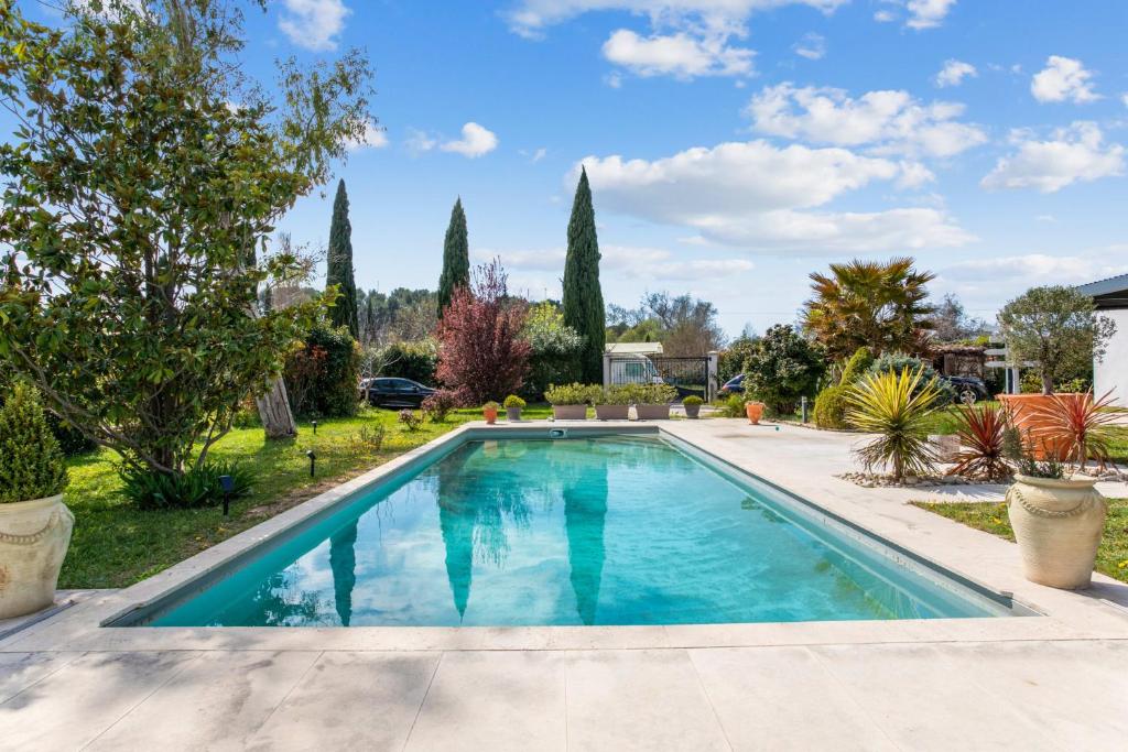 uma piscina no quintal de uma casa com árvores em Villa Massilia - Welkeys em Aubagne