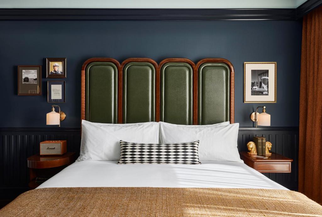 a bedroom with a large bed with blue walls at The Manchester Hotel in Lexington