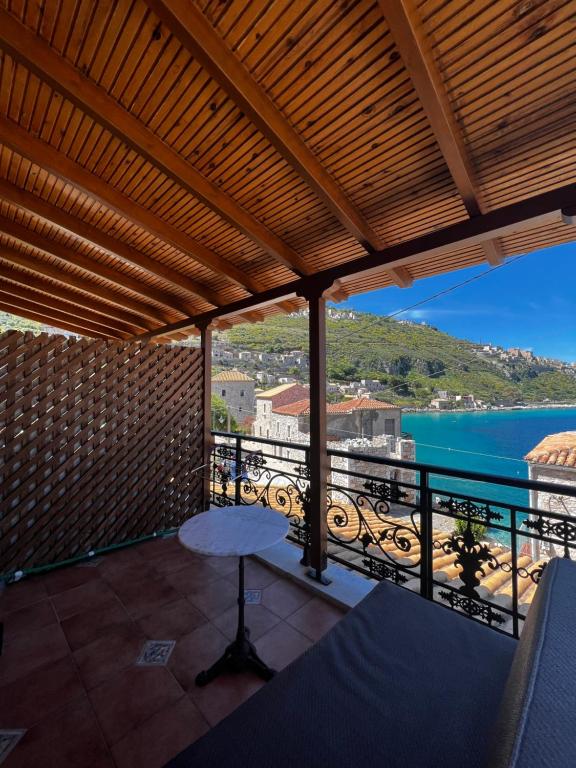 a balcony with a table and a view of the water at Limeni Studios in Limeni