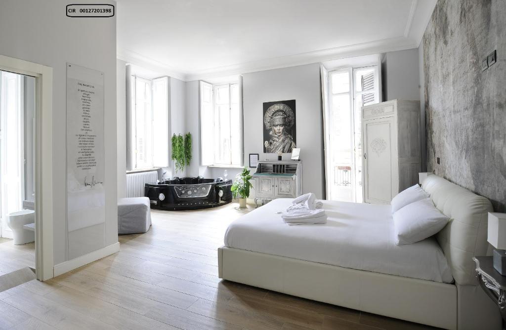 um quarto branco com uma grande cama branca num quarto em Apartments Chic Torino Centro em Turim