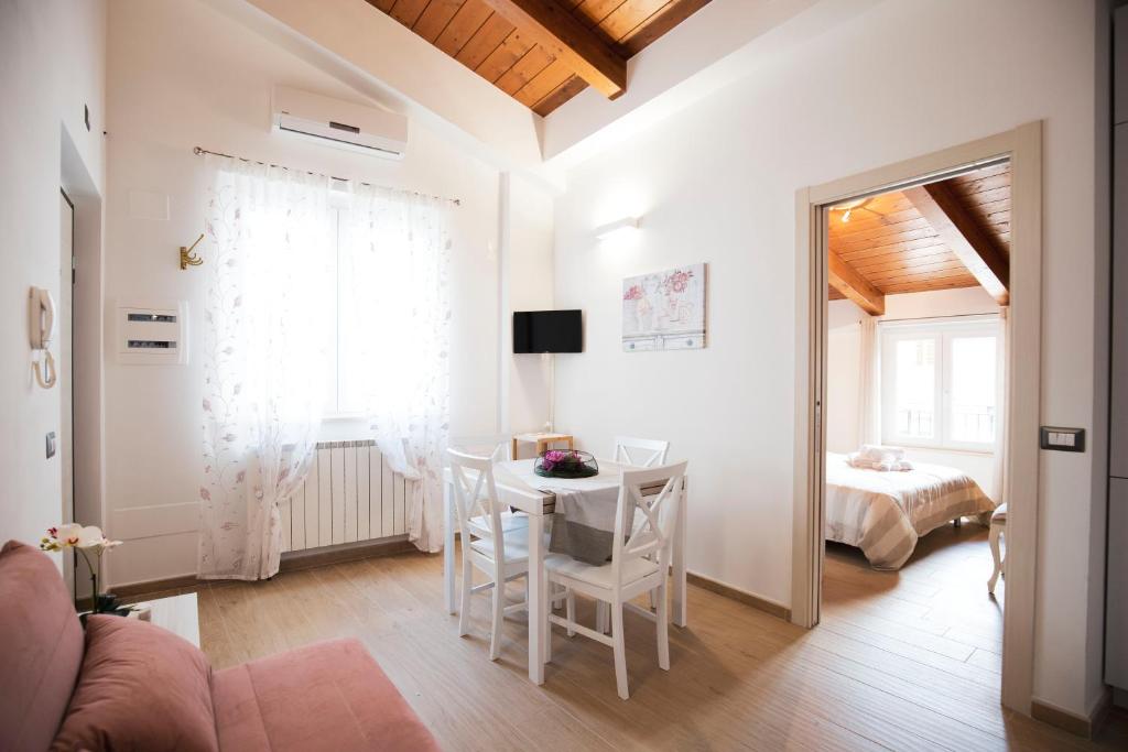 ein Wohnzimmer mit einem Tisch und einem Bett in der Unterkunft Appartamento Viale Patrono d'Italia in Santa Maria degli Angeli