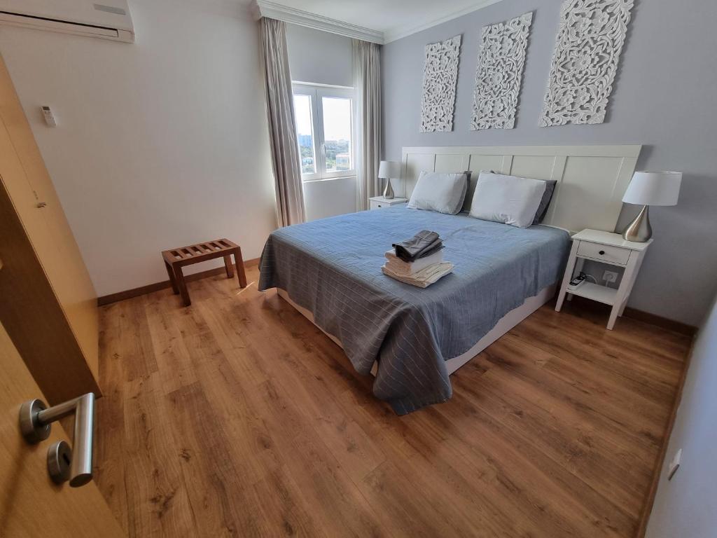 um quarto com uma cama com uma colcha azul em Brisa Atlântica em Portimão