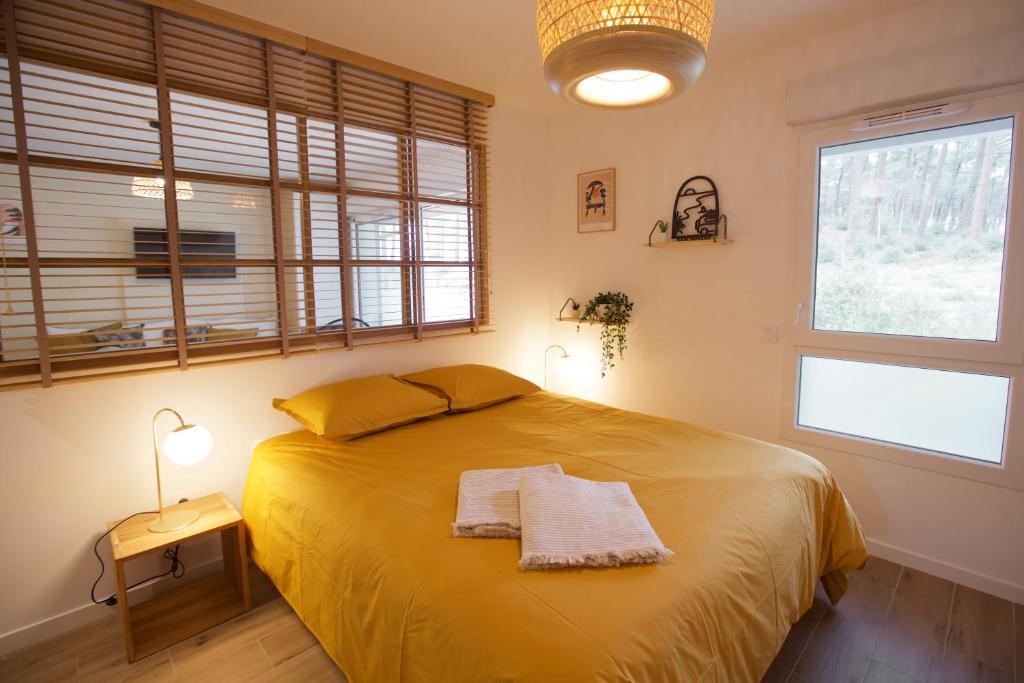 ein Schlafzimmer mit einem großen Bett mit zwei Handtüchern darauf in der Unterkunft * Seignosse * Plage * Forêt * Couple * Famille in Seignosse