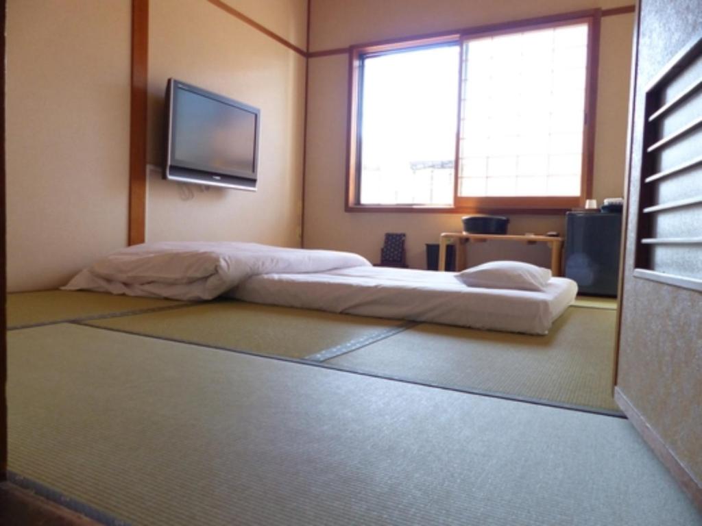 1 dormitorio con 1 cama y TV de pantalla plana en Minshuku Kuwataniya - Vacation STAY 96460v en Takayama