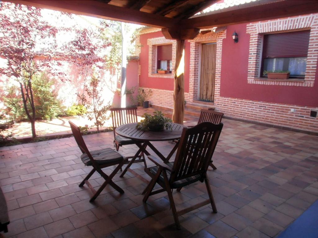 a patio with a table and chairs on a patio at La Cochera de Don Paco in Fresno de Cantespino