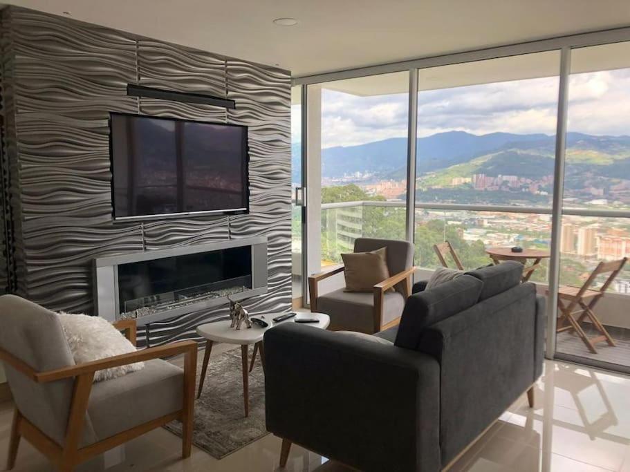 a living room with a fireplace and a tv on a wall at Apartamento con vista a Medellín in Medellín