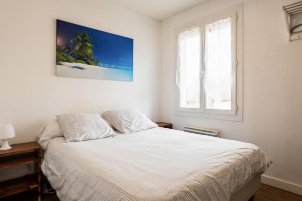 1 dormitorio con cama blanca y ventana en Villa des Palmiers, Chambre 3, Lit double, en Villeneuve-sur-Lot