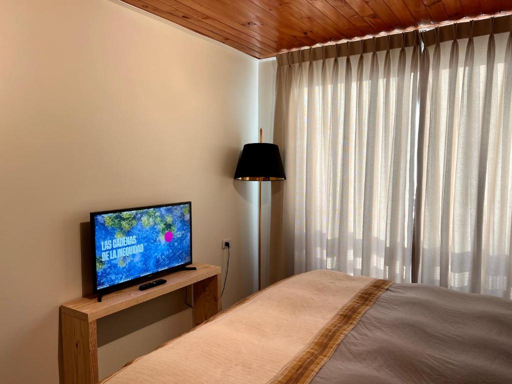 1 dormitorio con 1 cama y TV de pantalla plana en Golondrina El Tabo, en Las Cruces