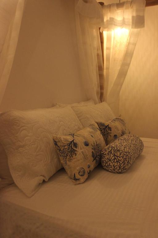 un letto con tre cuscini sopra di Casa Teresa Hotel a Cartagena de Indias