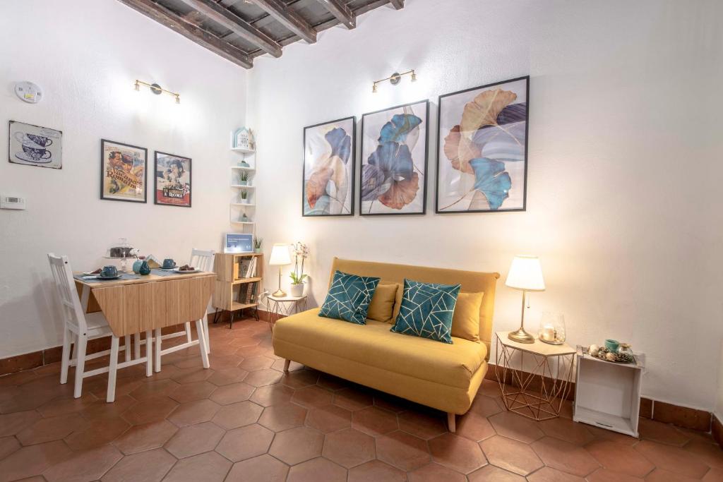 sala de estar con sofá amarillo y mesa en Stranamore Apartments Trastevere, en Roma