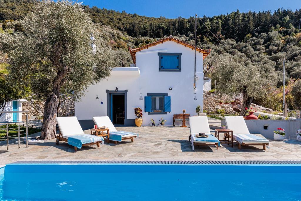 a villa with a swimming pool and a house at Villa Nirvana in Skopelos Town