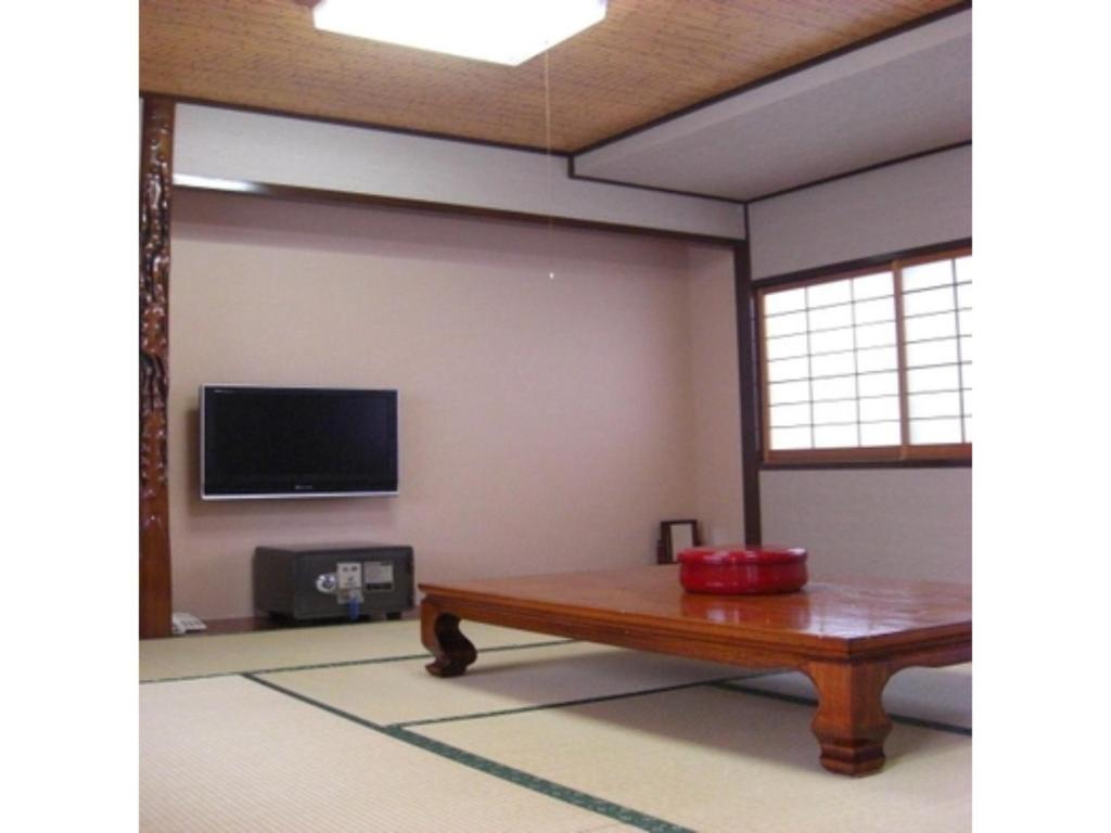 a living room with a table and a flat screen tv at Minshuku Kuwataniya - Vacation STAY 96483v in Takayama