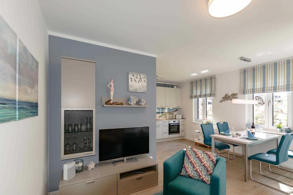 a living room with a dining table and a television at APPARTEMENT TRAUMSTERN 21 - zum Strand wenige Geh Minuten in Baabe