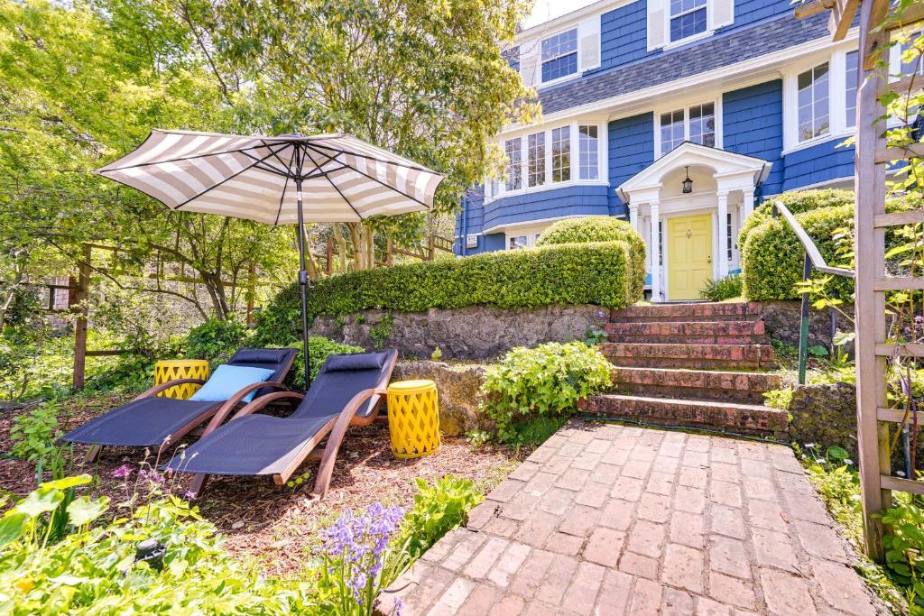 a patio with chairs and an umbrella in front of a blue house at Berkeley Home with Garden, Close to San Francisco! in Berkeley