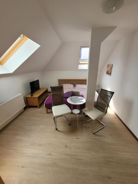 Habitación con mesa y sillas en un ático en Pension Schützenhaus Leisnig en Leisnig