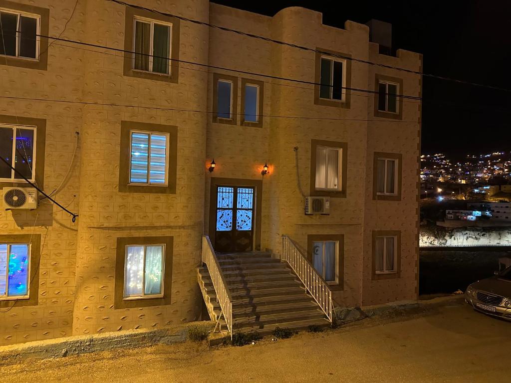 a building with stairs in front of it at night at Hustle's look in Wadi Musa