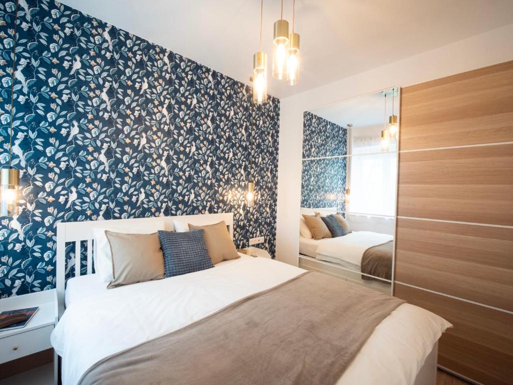 a bedroom with a bed with a blue and white floral wallpaper at Blue Bird Citadel Apartment in Budapest