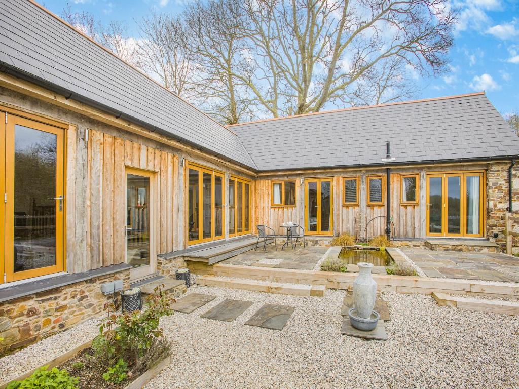 a wooden house with a patio in front of it at Olive Barn in Witheridge