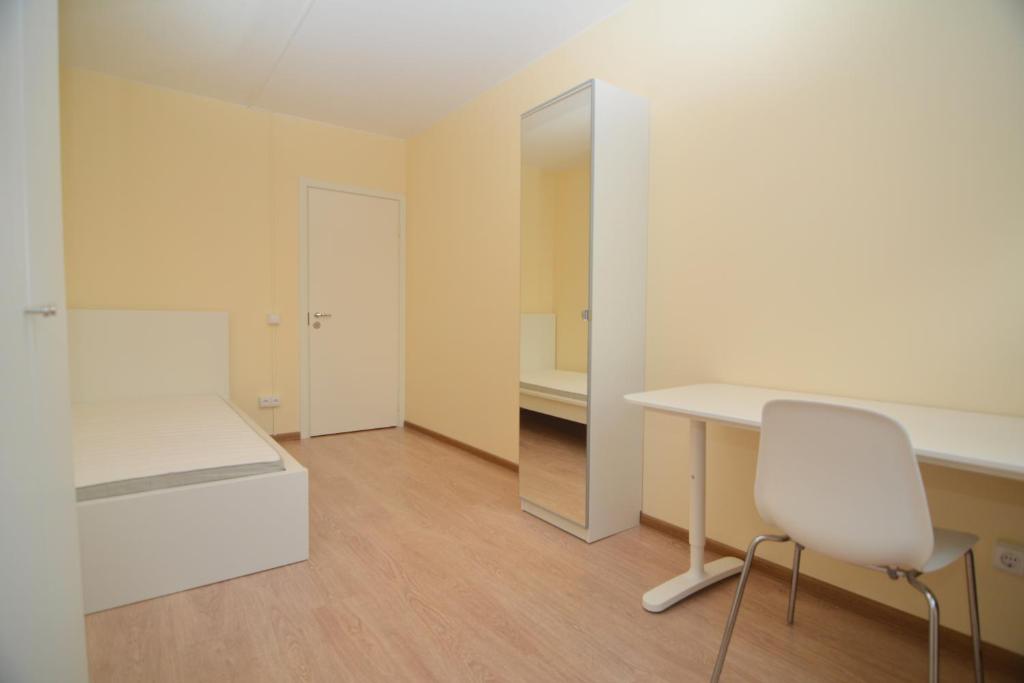 einen weißen Schreibtisch und einen Stuhl in einem Zimmer in der Unterkunft Pramonės av 77 Kaunas Students Home LT in Kaunas