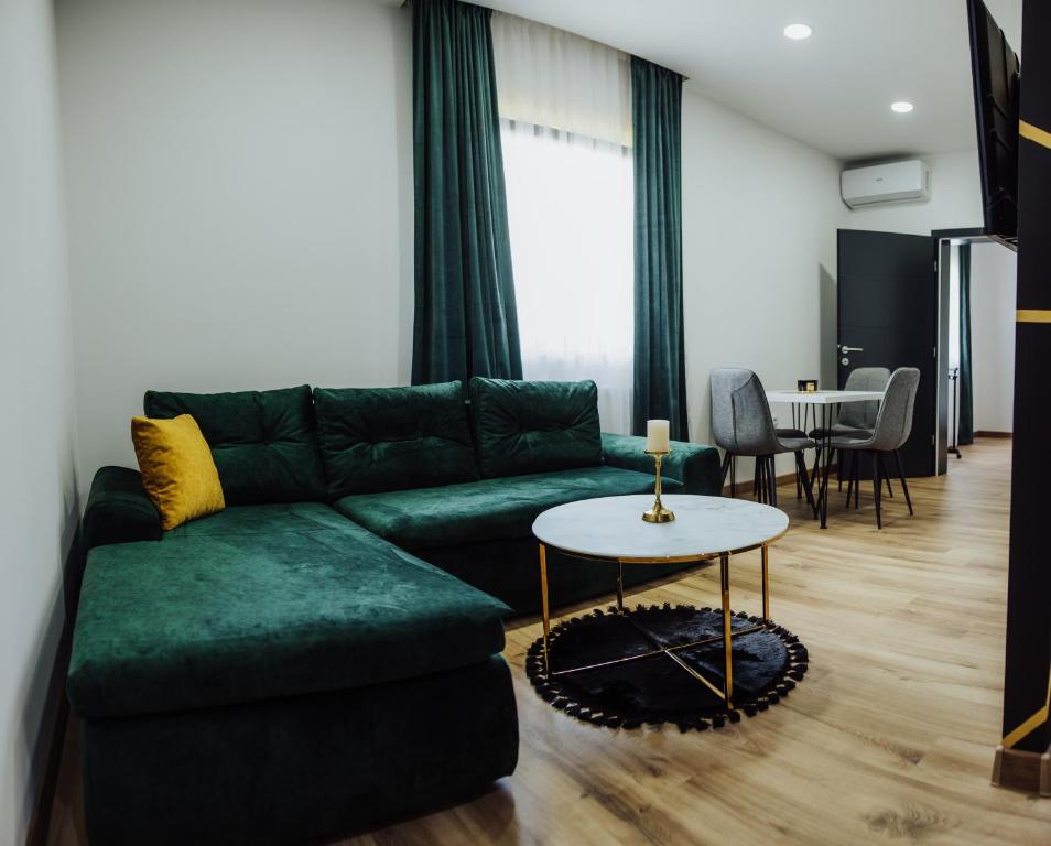 ein Wohnzimmer mit einem grünen Sofa und einem Tisch in der Unterkunft Modern Apartment 3 in Brčko
