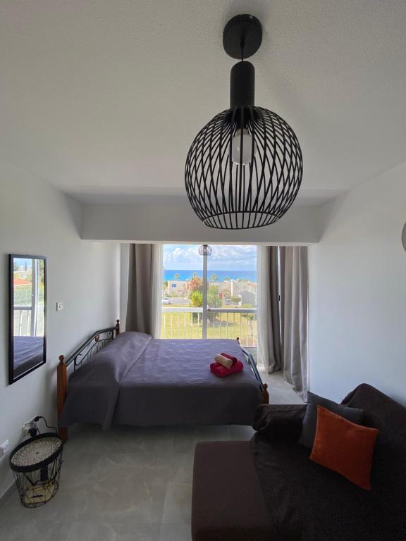 um quarto com uma cama e uma grande janela em Cozy Coral Bay Studio by the sea em Coral Bay