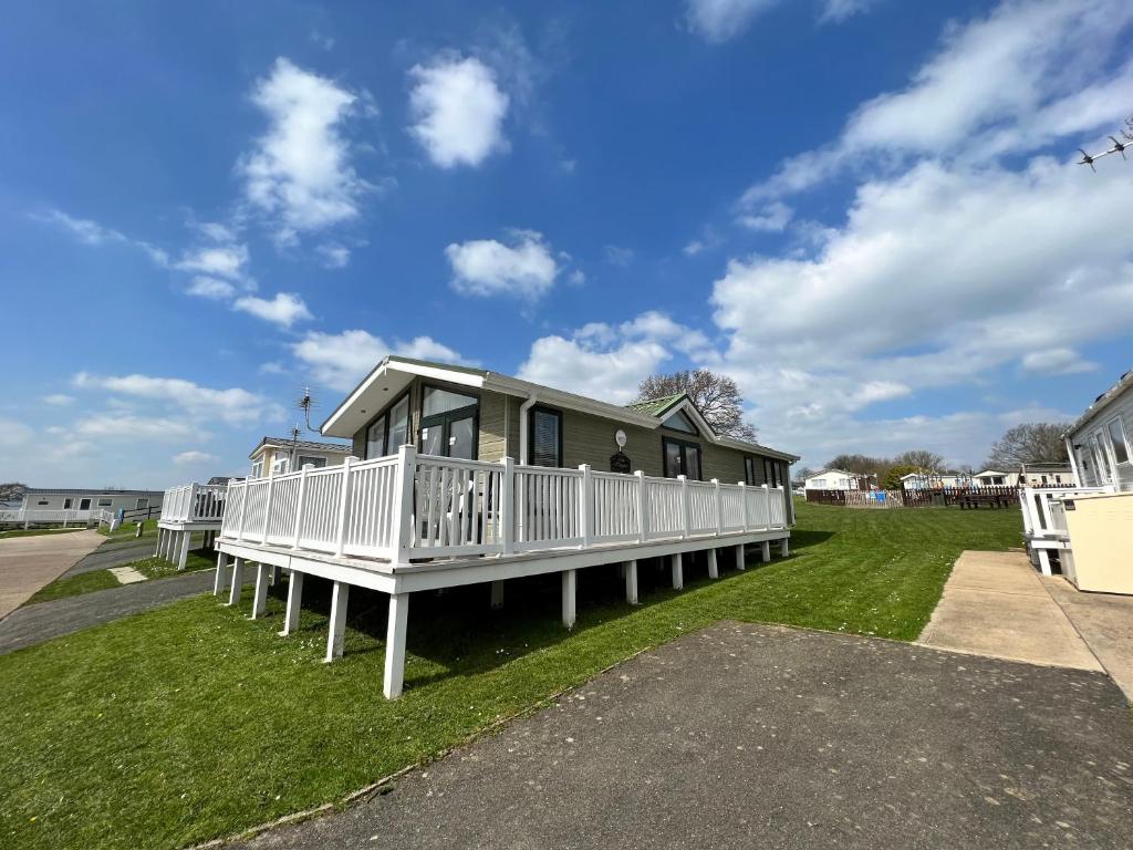 ein Haus mit einer Veranda auf dem Rasen in der Unterkunft 2 Bedroom Lodge TH35, Nodes Point, St Helens, Isle of Wight in Saint Helens