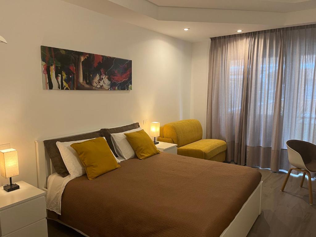 1 dormitorio con 1 cama grande y 1 silla amarilla en Anastasio Vatican Rooms G H en Roma