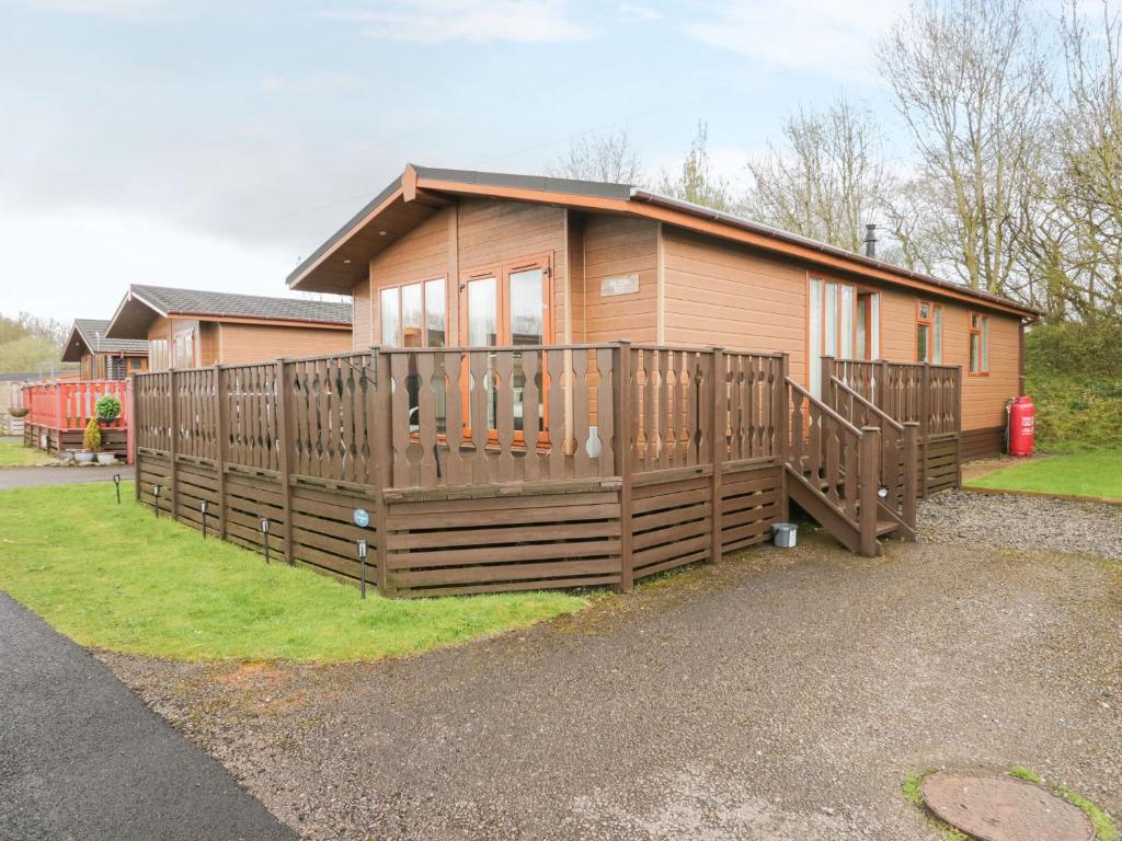 a small house with a large wooden deck at Walkers Rest in Carnforth