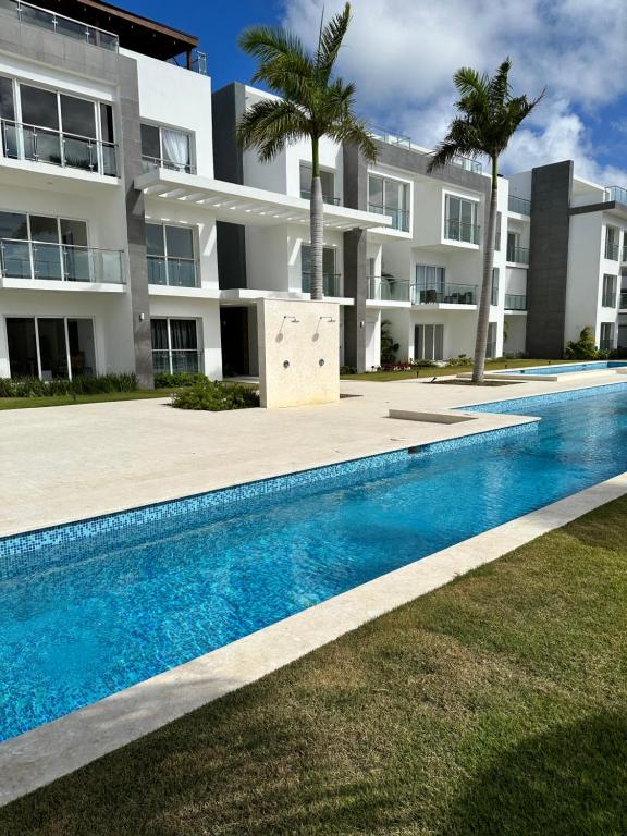a swimming pool in front of a building at LUXURY CONDO Cana Bay 1 CLUB BEACH in Punta Cana