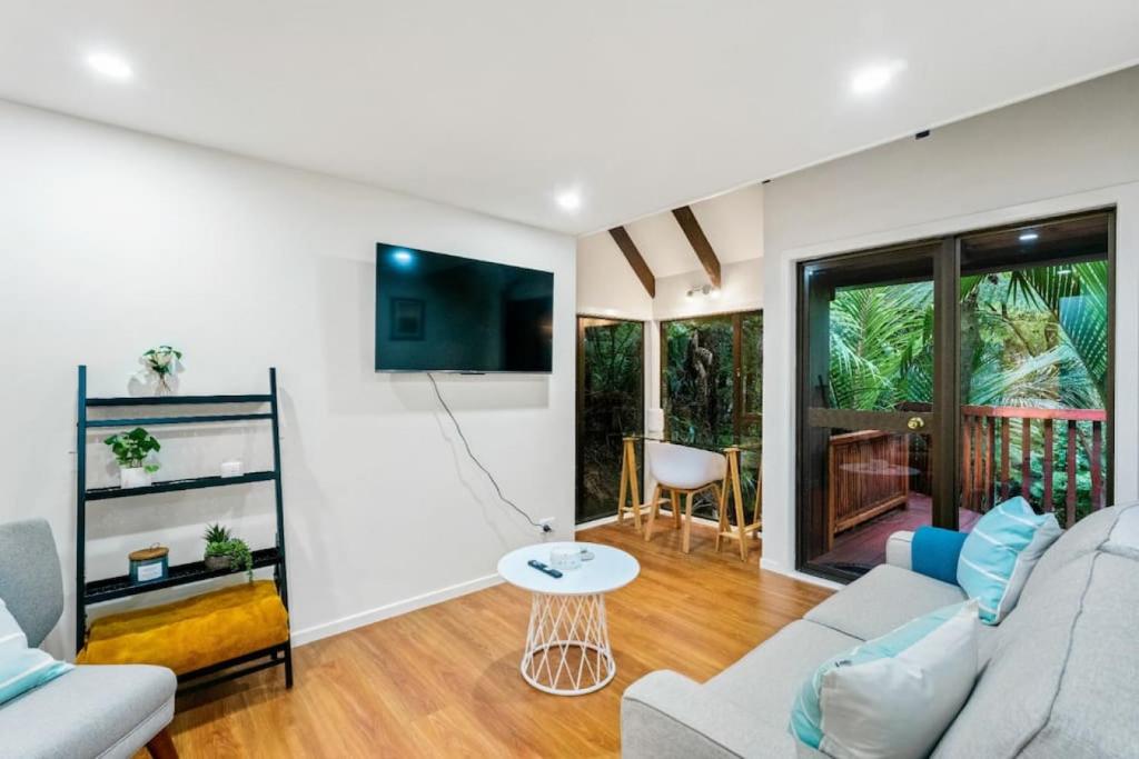 sala de estar con sofá y mesa en A 1BR slice of Titirangi Heaven - WiFi - Netflix en Auckland