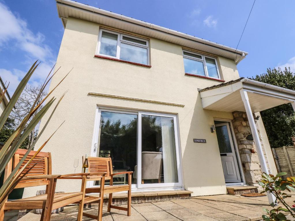 una casa con dos sillas y una mesa frente a ella en Altair, en Freshwater