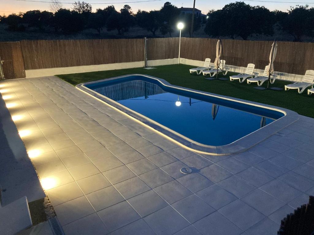 una piscina in un cortile con luci di Casa Rural Los Jarales Número Registro TR-CC-00365 a Casar de Cáceres