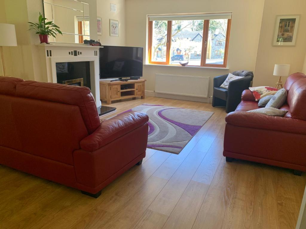 a living room with two couches and a television at Lough Rynn-Lord Leitrim in Rivers Town