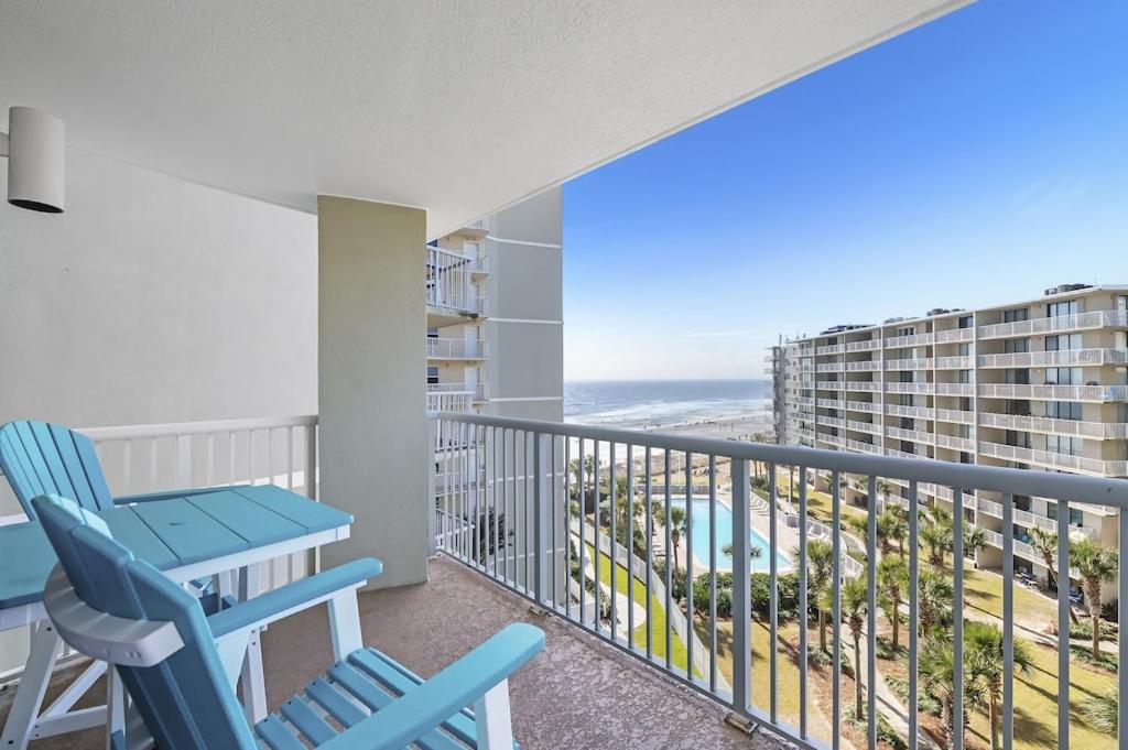 a balcony with a table and chairs and the ocean at Tradewinds Unit 608 in Orange Beach