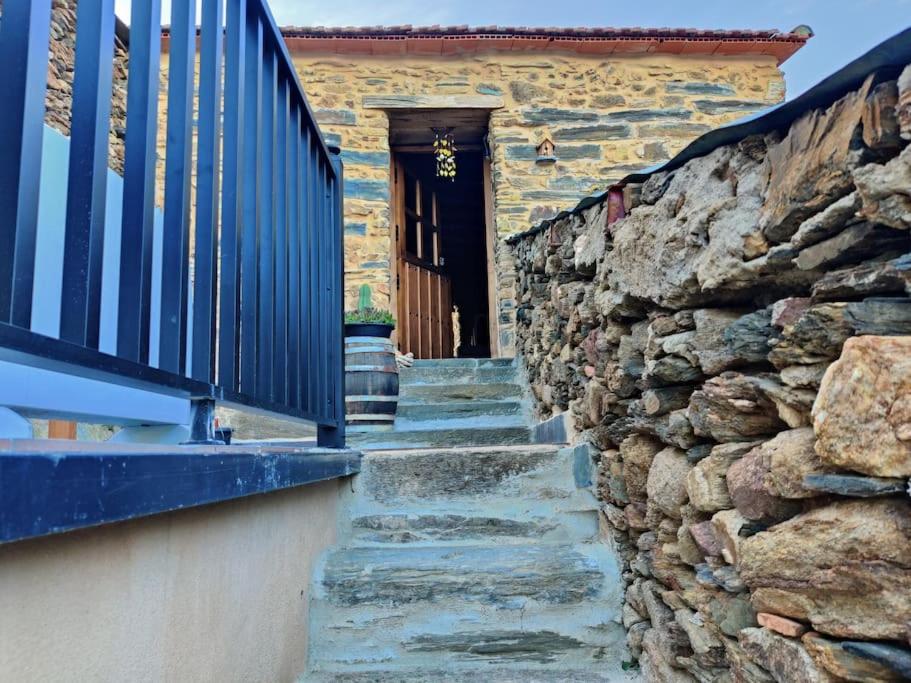 una pared de piedra con escaleras que conducen a una puerta en Casita de Florita, en Doade